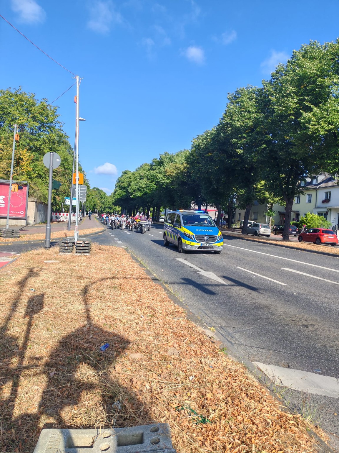 Langer Fahrradbus mit Kindern und Polizeibegleitung